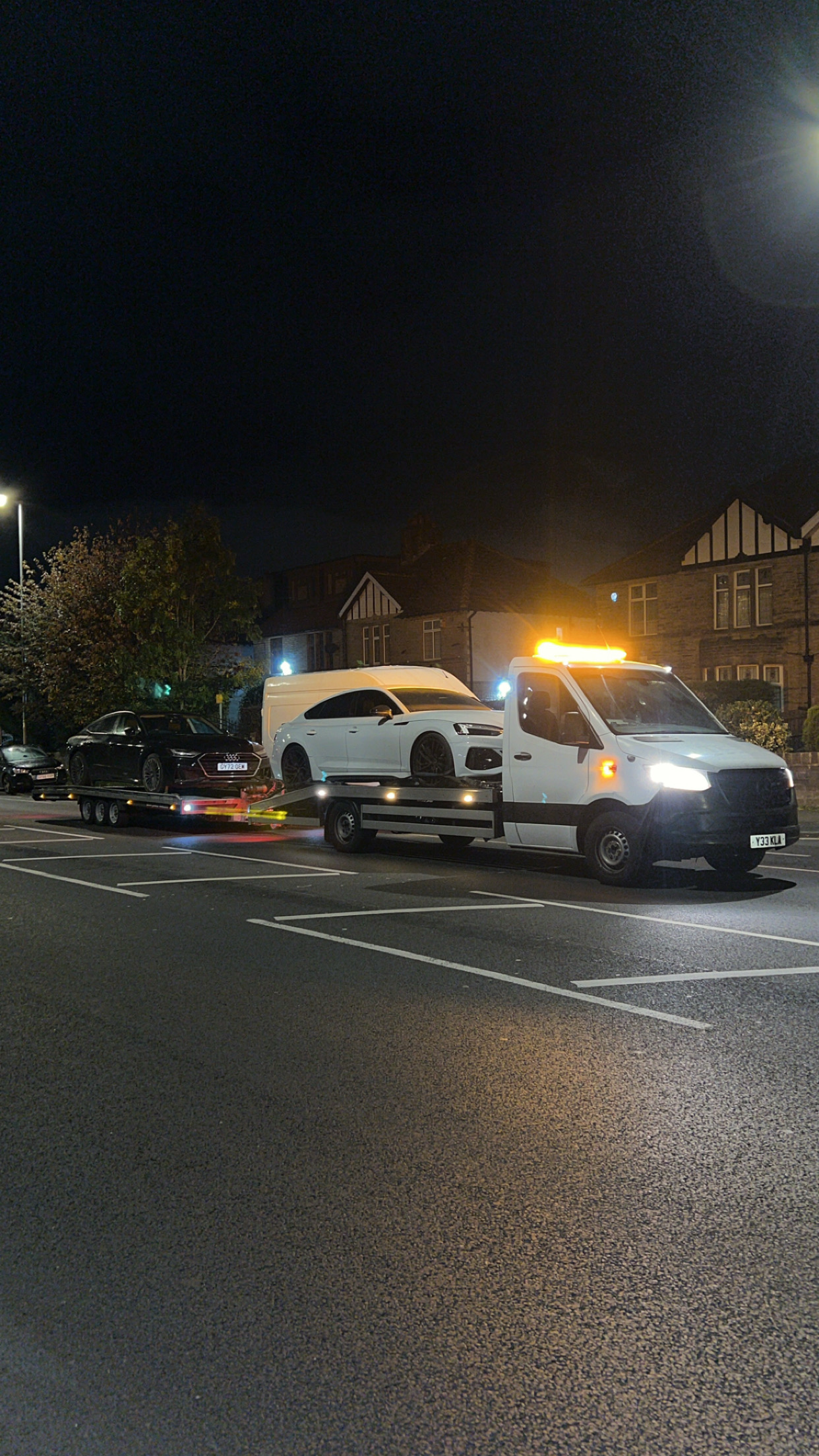 Fast Track Recovery transporting a vehicle on a recovery truck at night